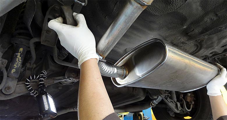 Mecânico revisando sistema de escapamento automotivo